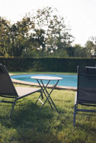 a table and two chairs sitting in the grass at La villa des Crénées in Héron