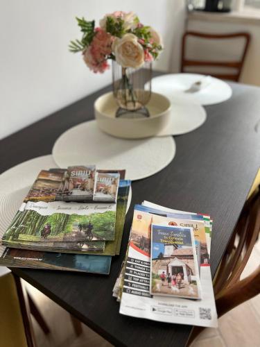 a table with two magazines and a vase with flowers at Atmosfera Sibiu in Sibiu