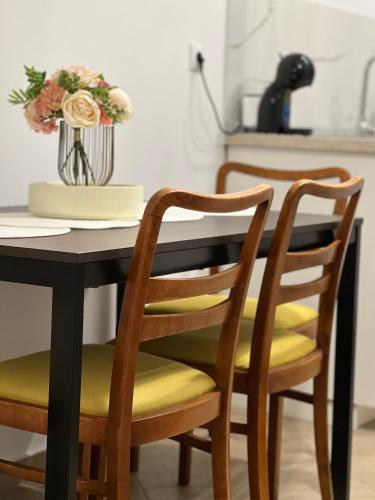 a black dining room table with yellow cushions and chairs at Atmosfera Sibiu in Sibiu