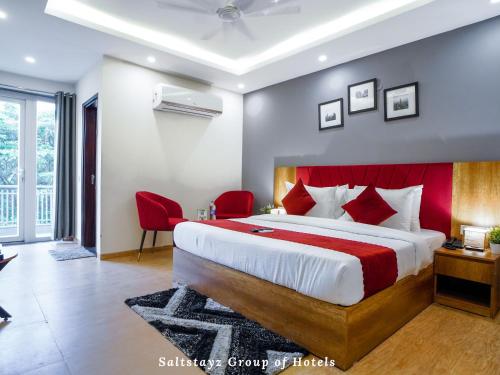 a bedroom with a large bed with a red headboard at Saltstayz Hotel Huda City Centre in Gurgaon