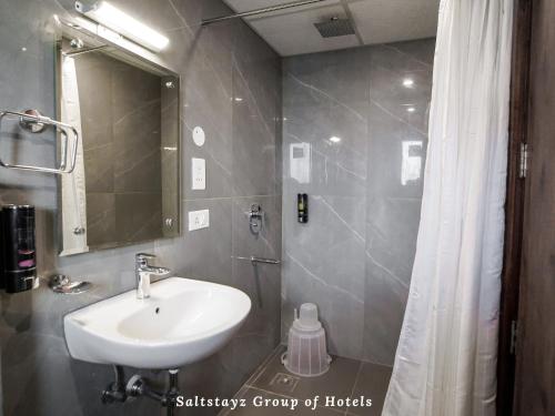 a bathroom with a sink and a mirror and a shower at Saltstayz Hotel Huda City Centre in Gurgaon