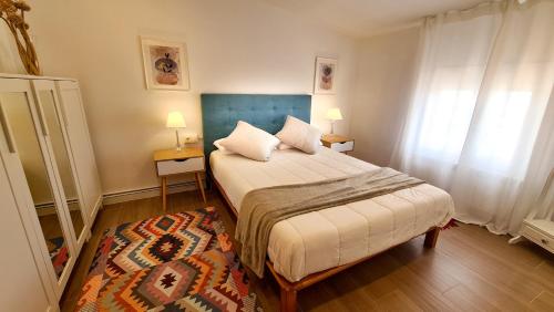 1 dormitorio con 1 cama, 2 lámparas y 1 alfombra en Casa deMáximo, en Navalpino