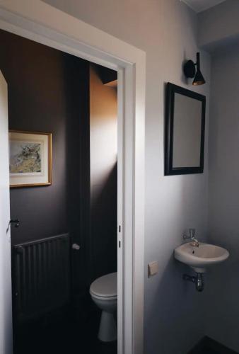 a bathroom with a toilet and a sink at La villa des Crénées in Héron