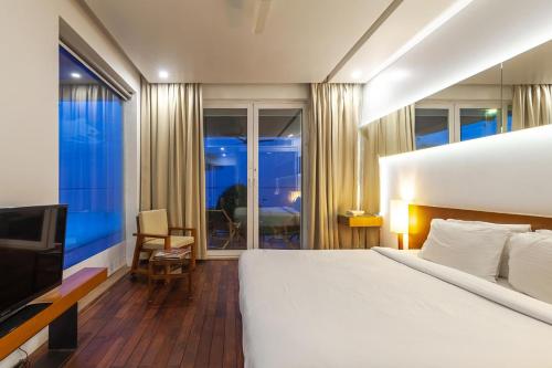 a bedroom with a large bed and a television at The Rain - River Villa with Infinity Pool in Alleppey