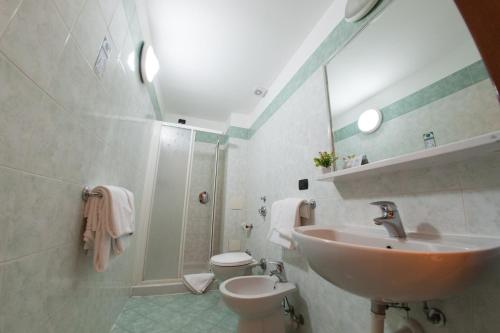 ein Bad mit einem Waschbecken, einem WC und einer Dusche in der Unterkunft The Best Hotel in Mailand