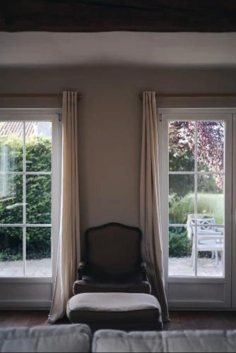 a living room with two windows and a couch at La villa des Crénées in Héron