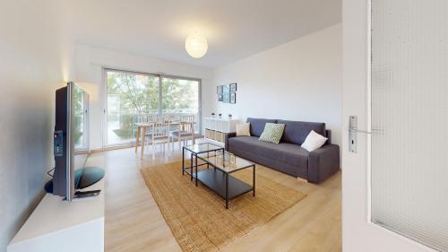 un salon avec un canapé et une table dans l'établissement Appartement La Fecht + parking, à Colmar