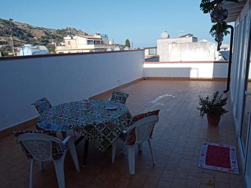 a patio with a table and chairs on a balcony at La Terrazza Solarium in Santa Flavia