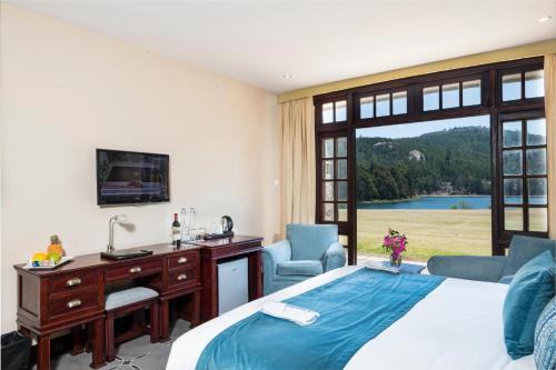 a bedroom with a bed and a desk with a computer at Troutbeck Resort in Nyanga