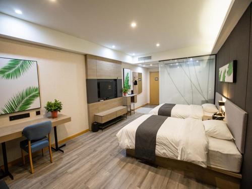 um quarto com 2 camas, uma secretária e uma televisão em Thank Inn Plus Jining Wenshang Baoxiang Temple em Wenshang