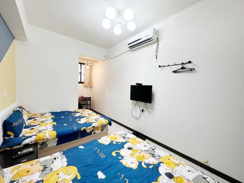 1 dormitorio con 2 literas y TV en 週週客棧, en Chia-hsiu