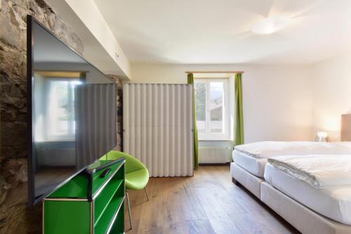 a bedroom with a bed and a flat screen tv at Hotel Sternen in Lenk