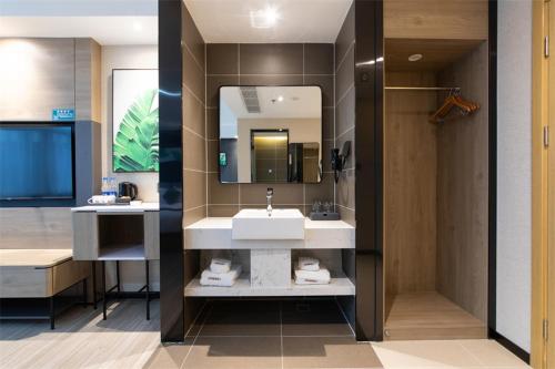 a bathroom with a sink and a mirror at Thank Inn Plus Suqian Shuyang Shandong Mall in Suqian