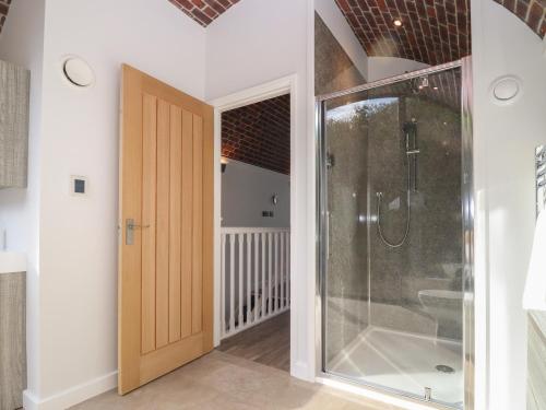 a bathroom with a shower and a glass door at The Tunnel at Bridge Lake Farm and Fishery in Banbury