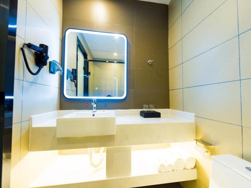 a bathroom with a sink and a mirror at Thank Inn Plus Datong Senyuan Building High-Speed Railway Station in Datong