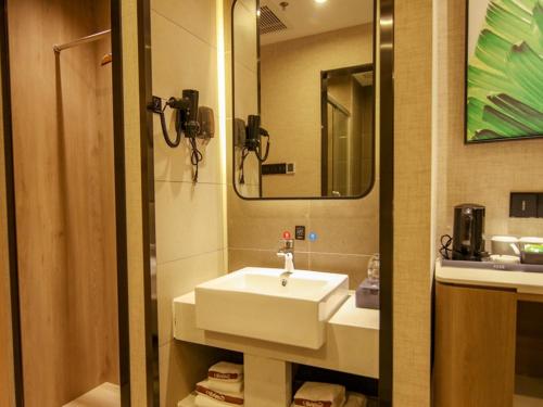 a bathroom with a white sink and a mirror at Thank Inn Plus Beijing Yizhuang Maju Bridge Jinghai Road in Tongzhou