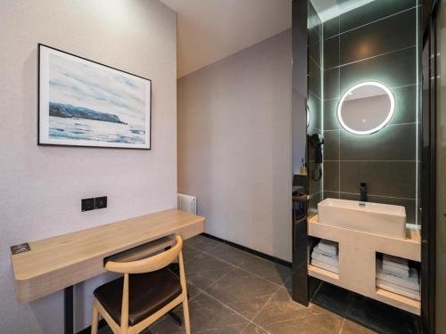 a bathroom with a sink and a glass shower at Feronia Hotel Beijing Bird's Nest Datun Road in Beijing