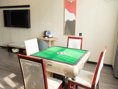 a room with a table and chairs and a tv at Thank Inn Plus Nanchang Longhu Paradise Street in Nanchang
