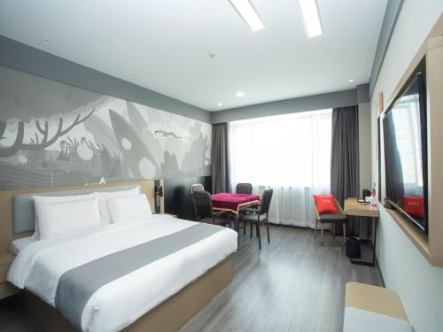 a hotel room with a bed and a table and chairs at Thank Inn Hotel Changsha Ningxiang Avenue High-Speed Railway Station in Ningxiang