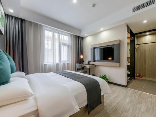 a hotel room with a large bed and a television at Thank Inn Plus Jiaozuo Jiefang District Heping Street in Jiaozuo