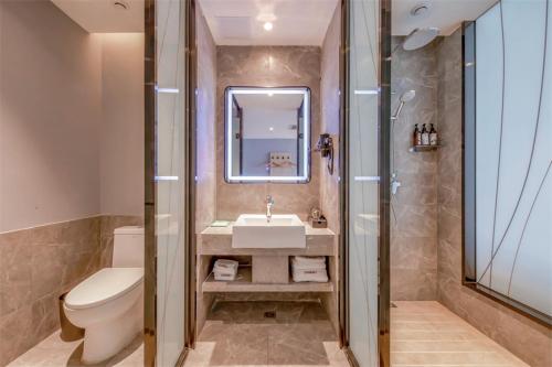 a bathroom with a sink and a toilet and a mirror at Thank Inn Plus Ordos Qipanjing Government Affairs Service Center in Shizuishan