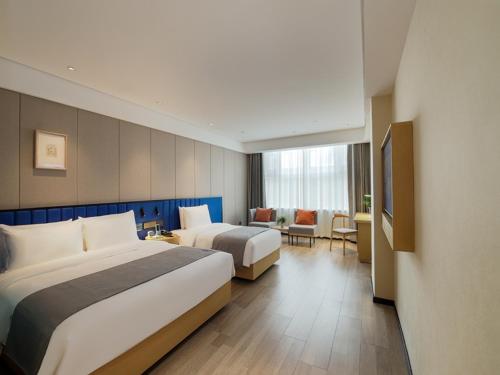 a hotel room with two beds and a couch at LanOu Hotel Taikoo Li Night Market Kuqa City in Kuqa