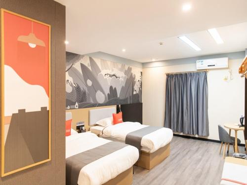a hotel room with two beds and a table at Thank Inn Plus Nanchang Longhu Paradise Street in Nanchang