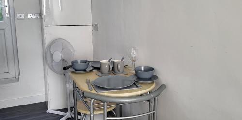 uma pequena cozinha com uma mesa com cadeiras e um frigorífico em Stadium Nook em Wembley