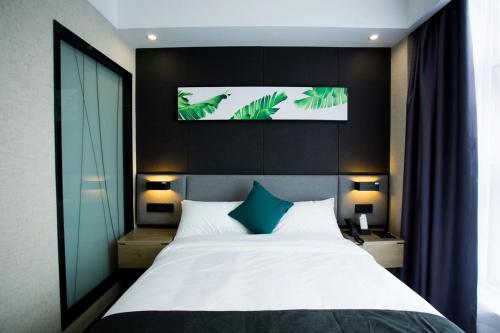 1 dormitorio con 1 cama grande y TV por encima. en Thank Inn Plus Yinchuan Dayue City en Yinchuan