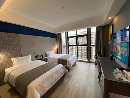 een hotelkamer met 2 bedden en een flatscreen-tv bij Thank Inn Plus Hanzhong High-Speed Railway Station in Hanzhong