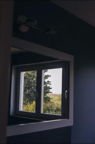 a mirror reflecting a window with a view of a field at La villa des Crénées in Héron