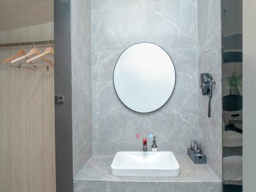 a bathroom with a white sink and a mirror at Thank Inn Hotel Changsha Ningxiang Avenue High-Speed Railway Station in Ningxiang