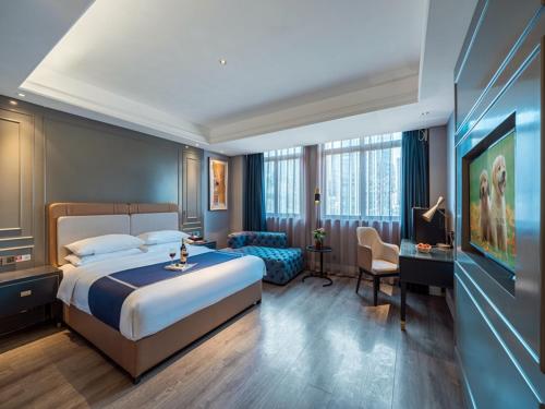 ein Hotelzimmer mit einem großen Bett und einem Schreibtisch in der Unterkunft LanOu Hotel Chongqing Hongou Square Wanzhou Guanyinyan in Wanzhou