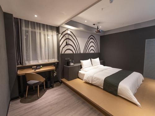 1 dormitorio con 1 cama grande, escritorio y escritorio en Thank Inn Plus Lanzhou New District Zhongchuan Airport Rainbow City, en Lanzhou