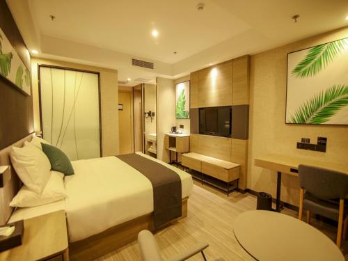 a hotel room with a bed and a desk and a television at Thank Inn Plus Beijing Yizhuang Maju Bridge Jinghai Road in Tongzhou