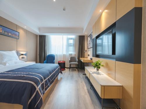 une chambre d'hôtel avec un lit et un bureau dans l'établissement LanOu Hotel Wuxi Anzhen East High-Speed Railway Station, à Wuxi