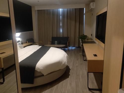 um quarto de hotel com uma cama grande e uma secretária em Thank Inn Plus Kashgar Shule 41st Caohu Town em Kashgar