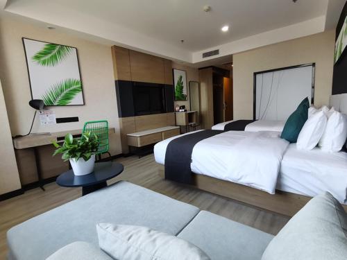 um quarto de hotel com duas camas e um sofá em Thank Inn Plus Aksu Kuqa Xingfu Road em Kuqa