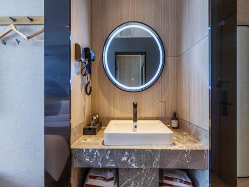 a bathroom with a sink and a mirror at Thank Inn Linyi Jiaxing Fruit Market in Linyi