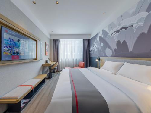 een hotelkamer met een groot bed en een televisie bij Thank Inn Linyi Jiaxing Fruit Market in Linyi