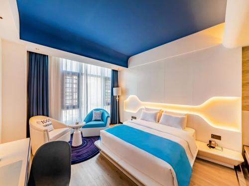 a bedroom with a large bed and a blue ceiling at LanOu Hotel Fuzhou Changle District Changle Airport in Fuzhou