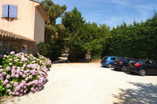 a group of cars parked next to a building with flowers at Le Mazet des Mûres in Grimaud