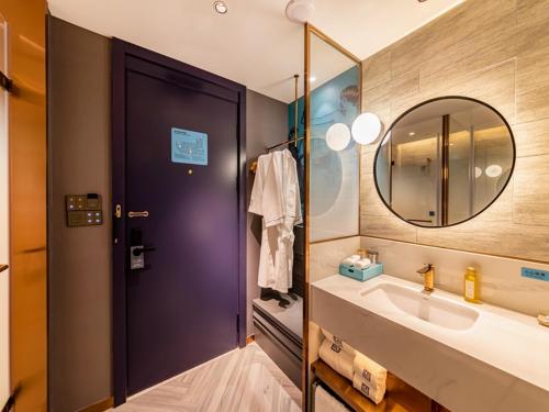 ein Bad mit einem Waschbecken und einem Spiegel in der Unterkunft LanOu Hotel Fuzhou Changle District Changle Airport in Fuzhou