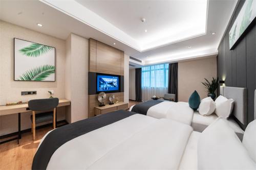 Xialian的住宿－尚客优品潮州潮安区彩塘镇卜蜂莲花酒店，一间卧室配有两张床、一张桌子和一台电视。