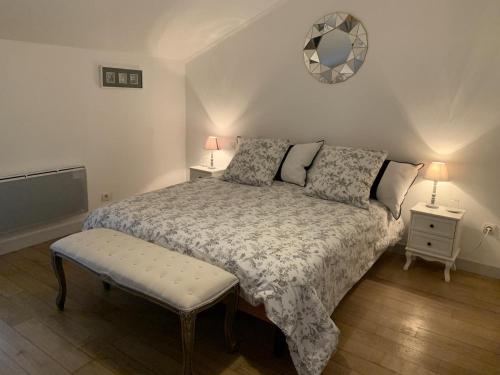 a bedroom with a bed and two tables and a mirror at Panissac in Berneuil