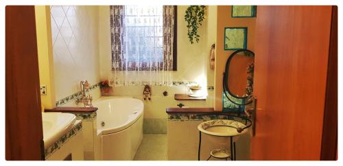 a bathroom with a tub and a sink and a bath tub at Dream of Chantal in Casal Palocco
