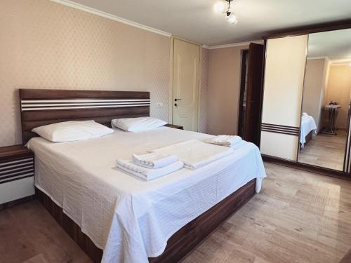 a bedroom with a large bed with towels on it at Gardenia in Tsqaltubo