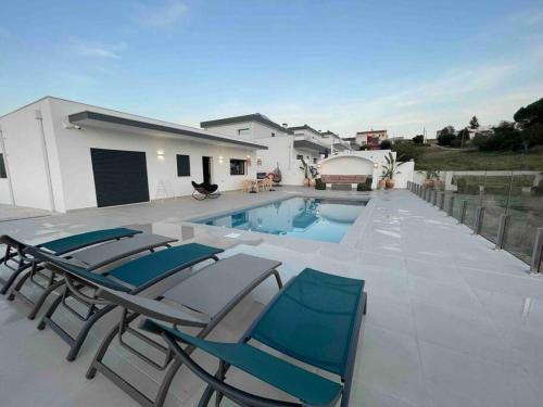 eine Terrasse mit 2 Stühlen und einem Pool in der Unterkunft Casas de Campo - Vale da Terça in Vermelho