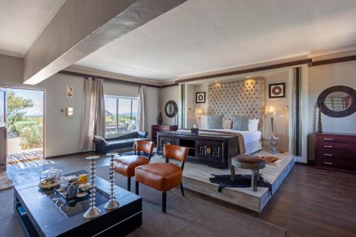 a bedroom with a bed and a living room at Inverdoorn Game Reserve Lodge in Breede River DC