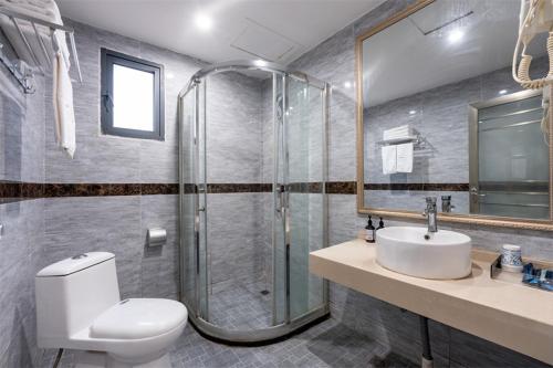 une salle de bain avec une douche, des toilettes et un lavabo dans l'établissement Junyi Hotel Wuhan Liuduqiao Subway Station, à Wuhan